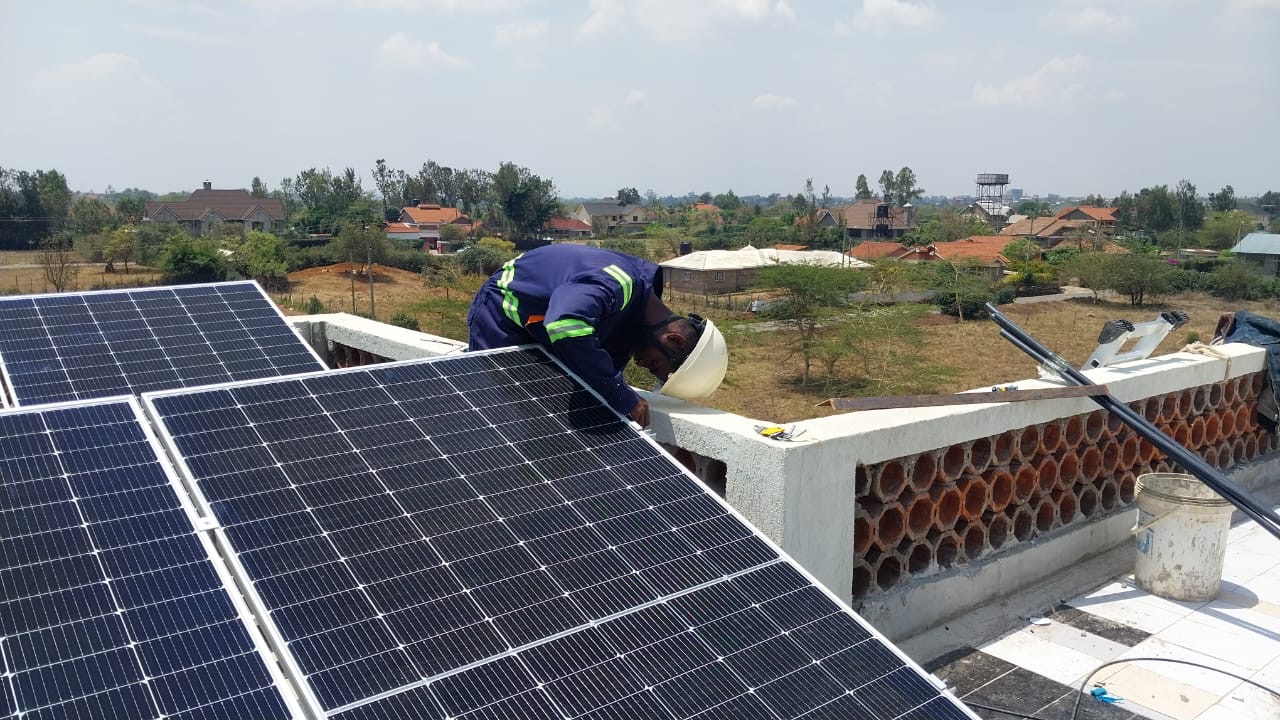 Certified solar technician securing panel connections on a residential roof